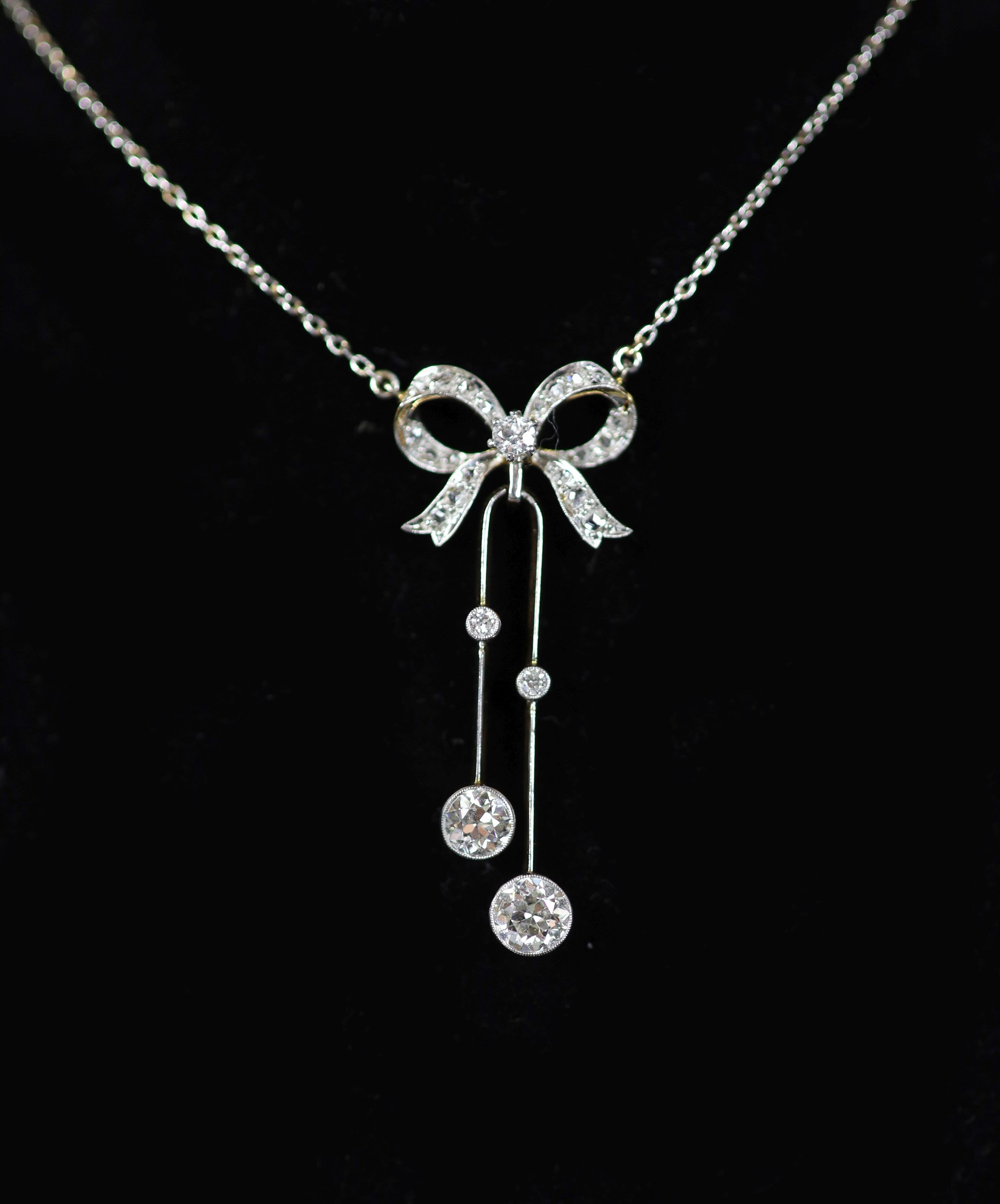 An early 20th century white and yellow gold, graduated diamond set double drop line pendant necklace